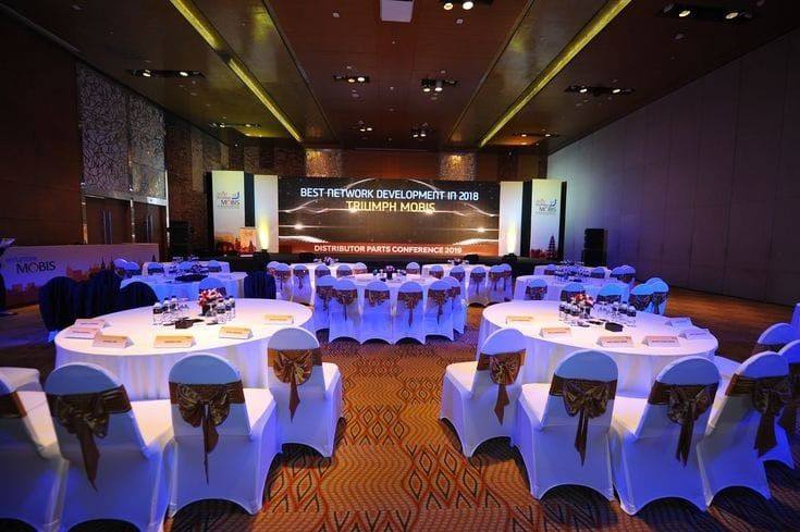 Corporate conference ballroom with round tables, stage and LED backdrop